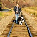 Annie Phenix and her dogs Echo and Radar walking on train tracks