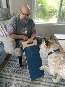 A Red heeler being taught to trim his nails using a scratch pad
